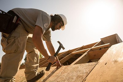 man putting plywood on roof